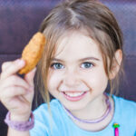 niña comiendo nuggets